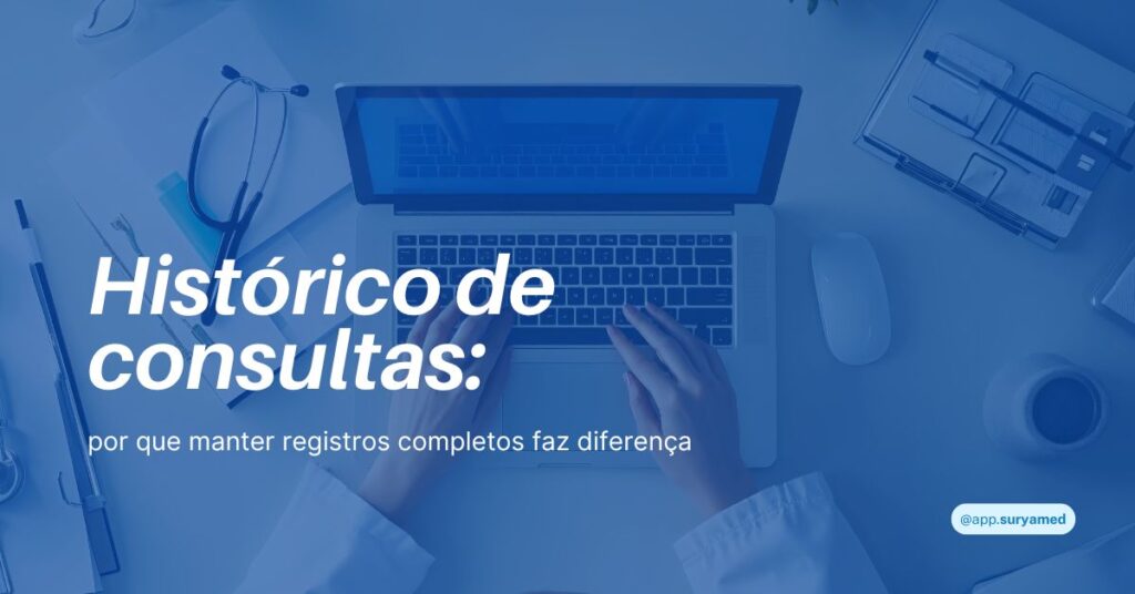 Pessoa usando jaleco médico digita em um laptop sobre mesa de trabalho com estetoscópio, canetas e papéis ao redor.